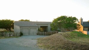 A residential property with a garage, a fenced yard, and a driveway leading to the house. - Oasis | Ocean Views & Private Hot Tub (Sea Ranch)