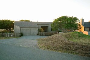 Ein Wohnhaus mit Garage, umzäunter Garten und Auffahrt zum Haus.