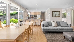 A modern kitchen with a dining area and a living room. - 6 BEDROOM FAMILIES SENSATION, LARGE HOLIDAY BEACH ENTERTAINER IN PORTSEA (Portsea)