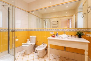 Une salle de bain équipée de toilettes, d’un bidet et d’un lavabo.