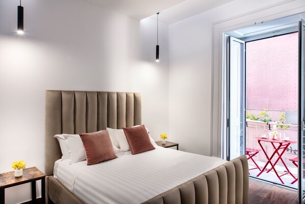 A modern hotel room with a large bed, a small bedside table, and a view of the outside balcony. - Residenza Toledo Lifestyle (Naples)