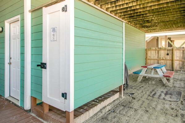 A small, single-story building with a green exterior and a white door. - South Shore Sea Esta - 5 BR Second Row Home - Pool & Kiddie Pool (Surf City)