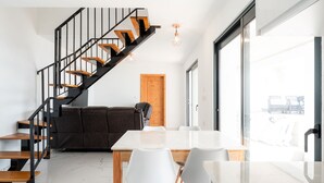 Un espace de vie moderne comprenant un escalier, un coin repas et une grande fenêtre.