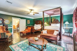 A four-poster bed, a wooden coffee table, a sofa, and a chair in a room with green walls and hardwood floors. - Historic 5,400-sq-ft Woodville Estate w/ Pool (Woodville)