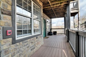 Un bâtiment en pierre doté d’une terrasse en bois et d’une porte verte.
