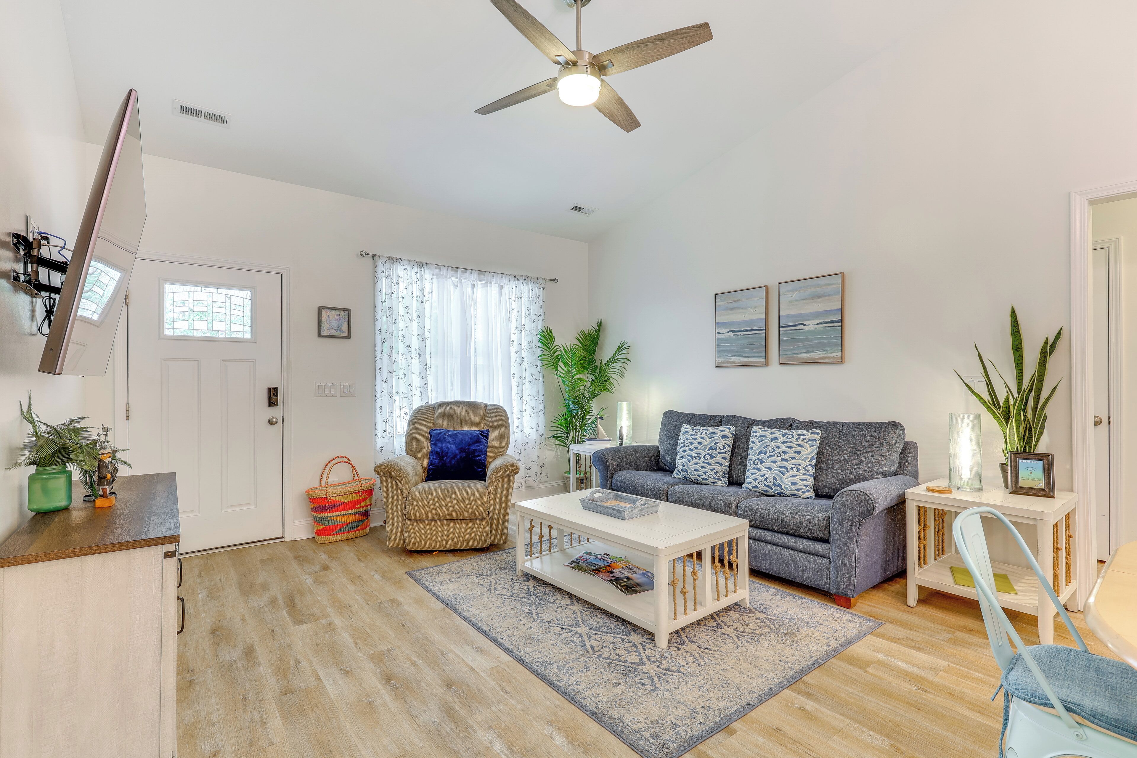 A living room with a ceiling fan, a sofa, a coffee table, and a chair.