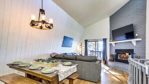 A dining area with a wooden table set for four, a bench, and a sofa in the background. - Colorful Running Springs Cabin w/ Incredible Views (Running Springs)