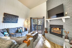 A cozy living room with a fireplace, a large flat-screen TV, and a comfortable seating area. - Colorful Running Springs Cabin w/ Incredible Views (Running Springs)