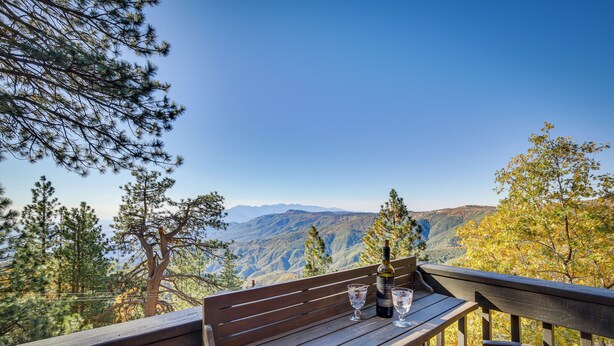 A wooden bench with a bottle and glasses on it, overlooking a mountainous landscape. - Colorful Running Springs Cabin w/ Incredible Views (Running Springs)
