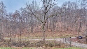 A forested area with a dirt path and a metal gate. - Pet-friendly Home ~ 10 Mi to Hocking Hills! (Laurelville)