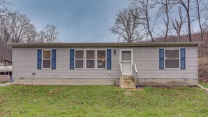 A single-story house with a front door, a small porch, and a garage. - Pet-friendly Home ~ 10 Mi to Hocking Hills! (Laurelville)