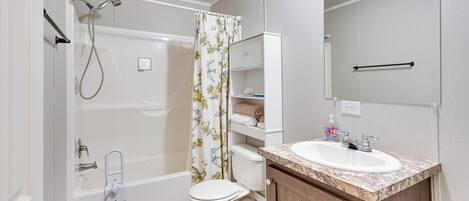 A bathroom with a shower, toilet, and sink.