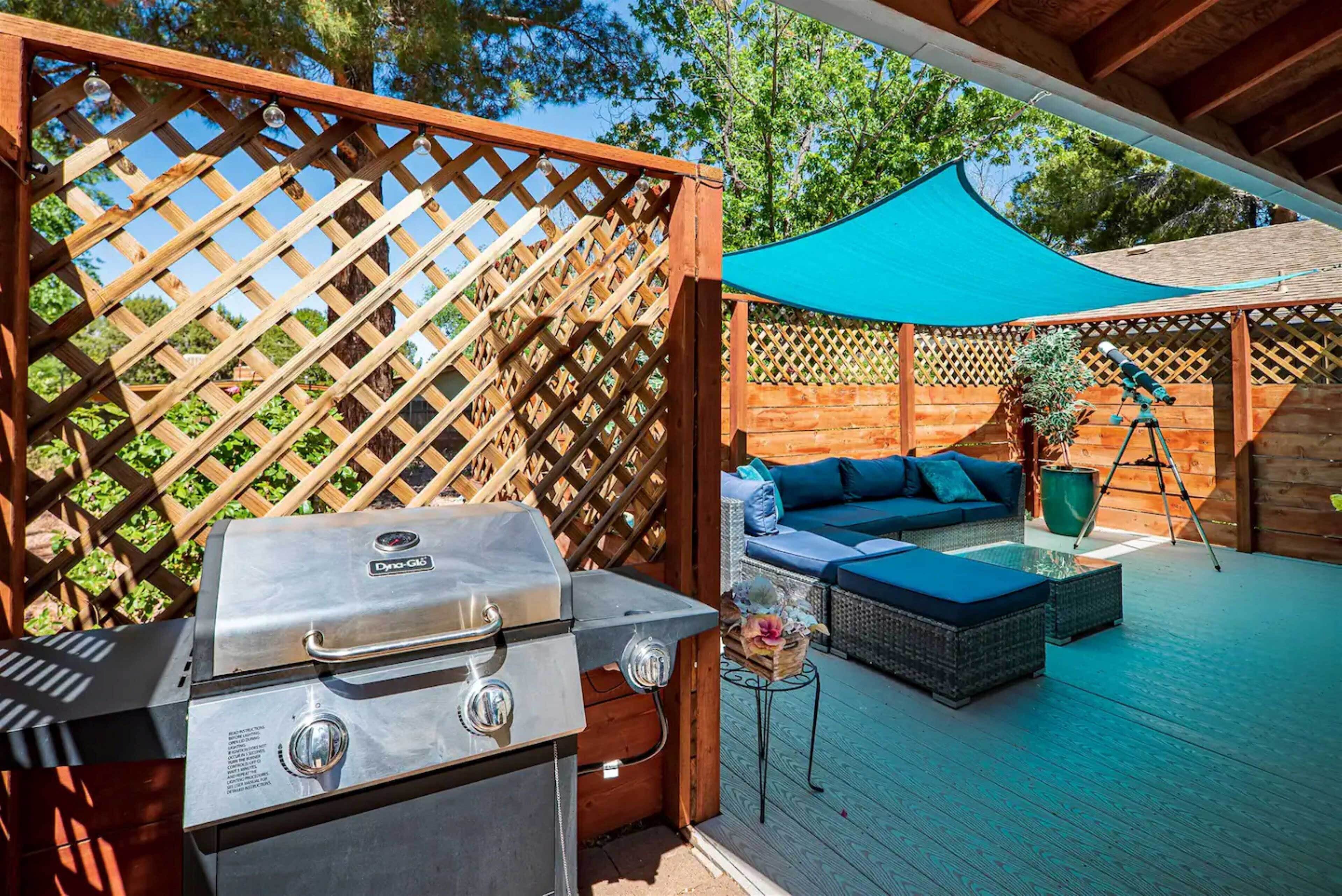 Une terrasse avec un barbecue, des sièges d’extérieur et un télescope.