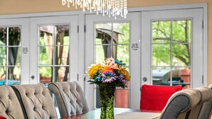 A dining area with a wooden table, cushioned chairs, a vase of flowers, and a chandelier. - 1 Mi to Trails: Pet-friendly Home in West Sedona! (Sedona)