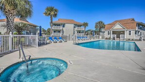 A pool area with two swimming pools, lounge chairs, and a palm tree. - NMB Condo: Walk to the Beach or Use the Pool! (North Myrtle Beach)