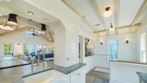 A spacious kitchen with a large island, white cabinetry, and a wooden ceiling. - Beachfront Luxury in Seaside, Sleeps 24! Wow Porches & Gulf Views + 2 Bikes! (Santa Rosa Beach Fl)