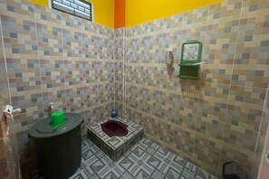 Ein kleines Badezimmer mit Fliesen, einer Toilette, einem Waschbecken und einer Duschkabine.