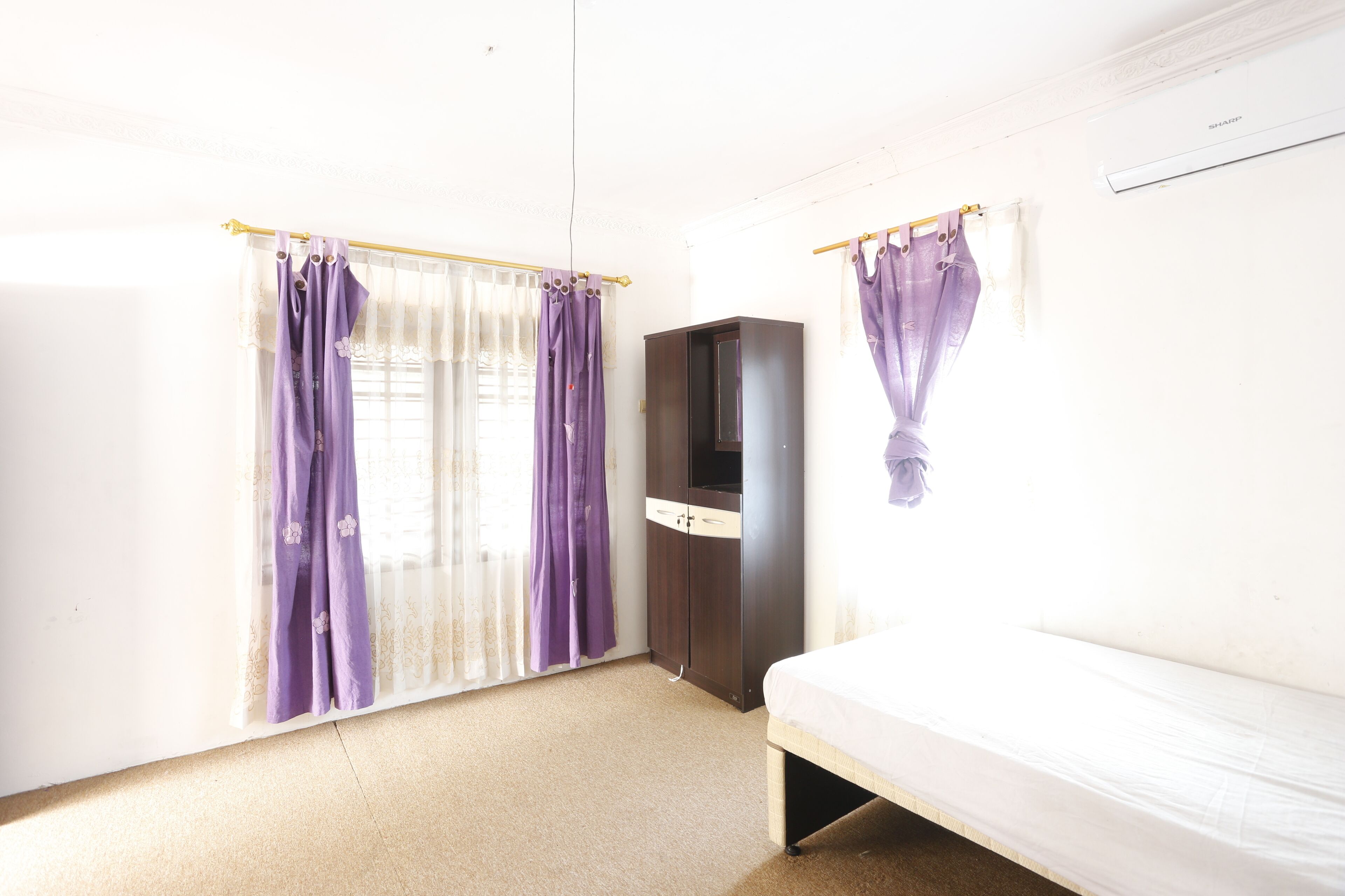 A room with a bed, a wardrobe, and a television.