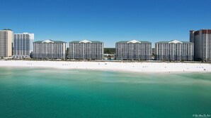 A beachfront hotel with multiple high-rise buildings, a sandy beach, and clear turquoise waters. - FREE Beach Service, Golf &Perks! Long Beach Tower 3-303, Hot Tub, Gym & Pools (Panama City Beach)