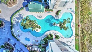 An aerial view of a resort with a large central pool, multiple lounge areas with sunbeds, and a surrounding landscaped area. - FREE Beach Service, Golf &Perks! Long Beach Tower 3-303, Hot Tub, Gym & Pools (Panama City Beach)