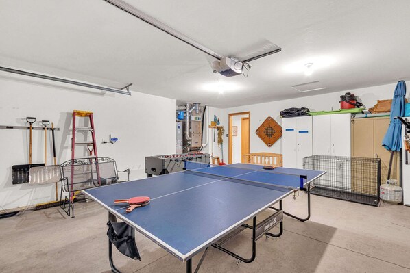 A ping pong table in a room with a ceiling fan, a ladder, and various items on shelves. - Updated 3 bedroom on Northside Sunriver, Hot tub, Pets ok (Sunriver)