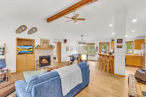 A spacious living area with a fireplace, a sofa, and a dining area with a bar. - Updated 3 bedroom on Northside Sunriver, Hot tub, Pets ok (Sunriver)