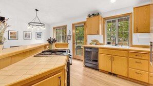 Una cocina moderna con armarios de madera, una isla grande y un lavavajillas.