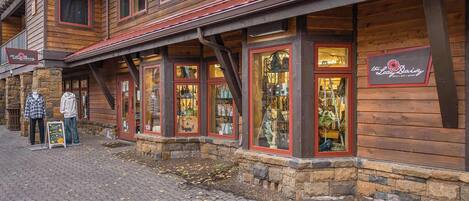 A rustic building with wooden exterior and large display windows.