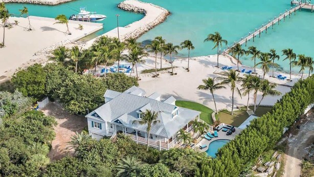 A beachfront property with a large house, a swimming pool, and a pier extending into turquoise waters. - Pineapple Beach (Islamorada)
