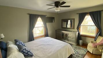 A bedroom with a bed, dresser, and chair.