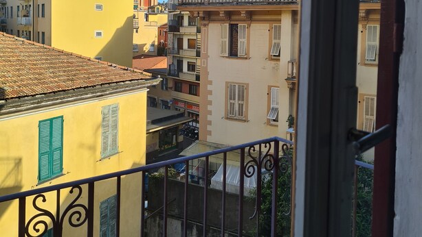A balcony with a view of a cityscape, including buildings with balconies and a tower. - Violetta Portofino by PortofinoVacanze  (Rapallo)