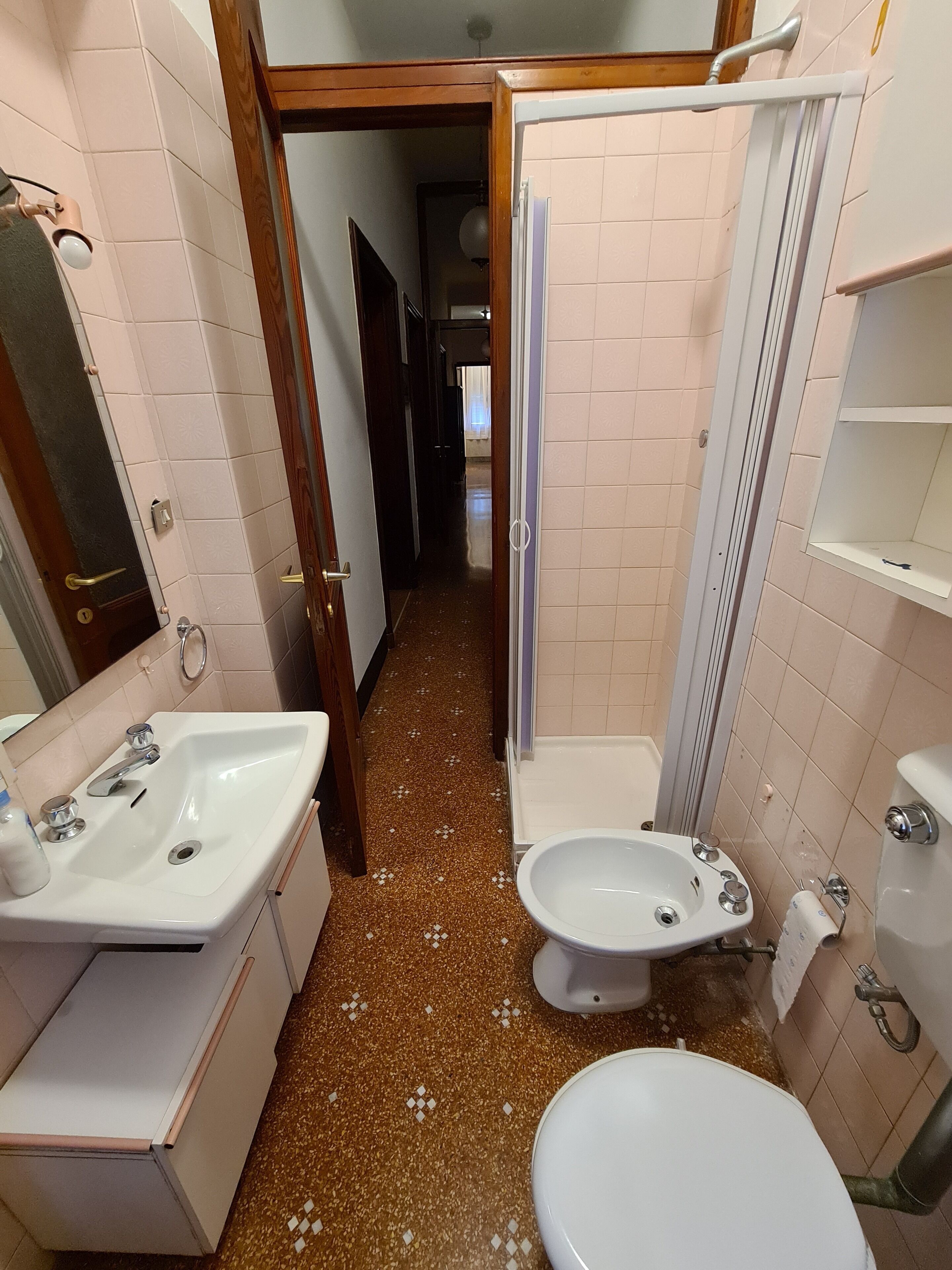 Un baño con lavamanos, bidé, inodoro y zona de ducha.