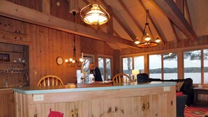 Ein Holzinterieur mit Barbereich, Holzsäulen und Seeblick.