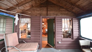 Een houten interieur met een bed, een stoel en een raam.