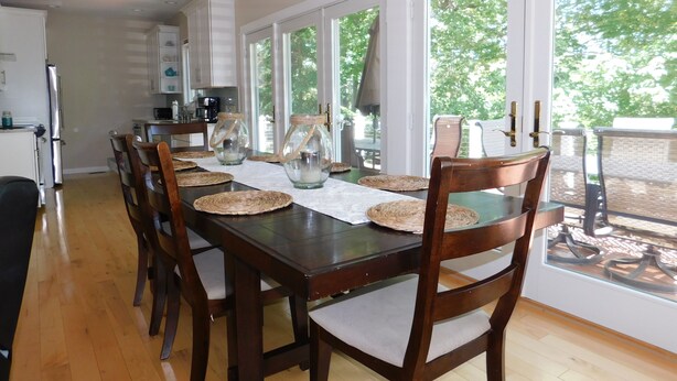 A dining area with a wooden table, woven placemats, and chairs.