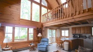 A spacious cabin with a loft bedroom, a dining area, and a kitchen.