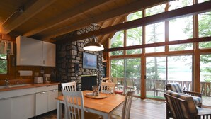 Una cocina amplia con chimenea de piedra, ventanas grandes y una terraza con mobiliario exterior.