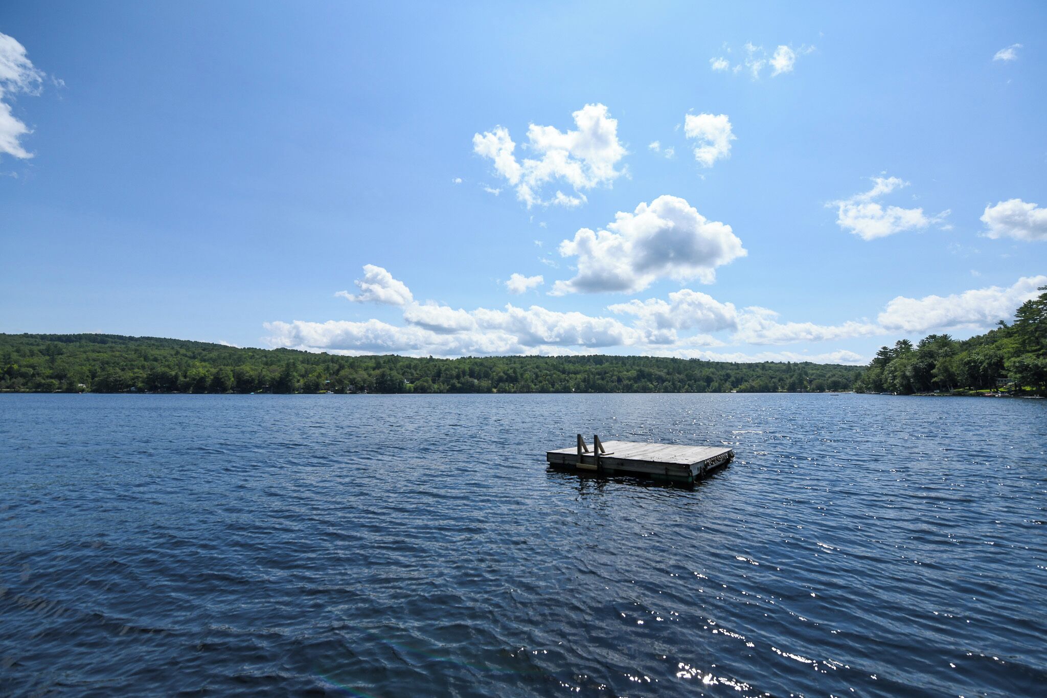 A calm lake with a wooden dock extending into the water.