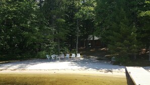Ein Strandbereich mit weißen Liegestühlen und einer Holzterrasse.
