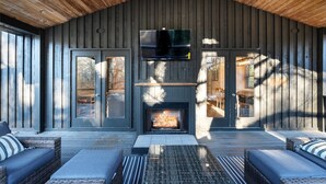 Een gezellig interieur met een open haard, comfortabele zithoek en een televisie erboven.