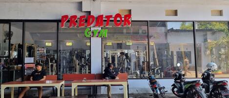 A gym named "Predator Gym" with a blue roof and large windows.