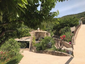 A rustic stone building with a sign reading "GLIE A FUNTANA".