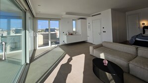 Un appartement moderne doté d’un balcon, d’une kitchenette, d’un canapé et d’un coin repas.