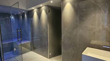 Bathroom features a glass shower enclosure, large mirror, and marble floor.