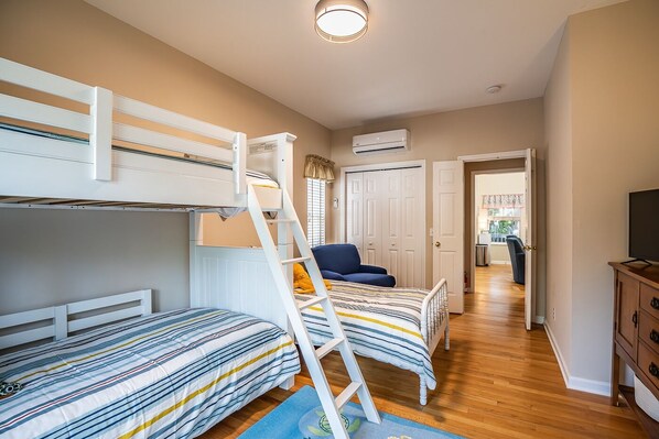 A bedroom with bunk beds, a desk, a chair, and a television. - Golf Cart included - 21 Davis Love (Fripp Island)