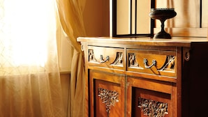 A wooden cabinet with intricate carvings and a decorative bowl on top. - Orfeo's House (Modena)