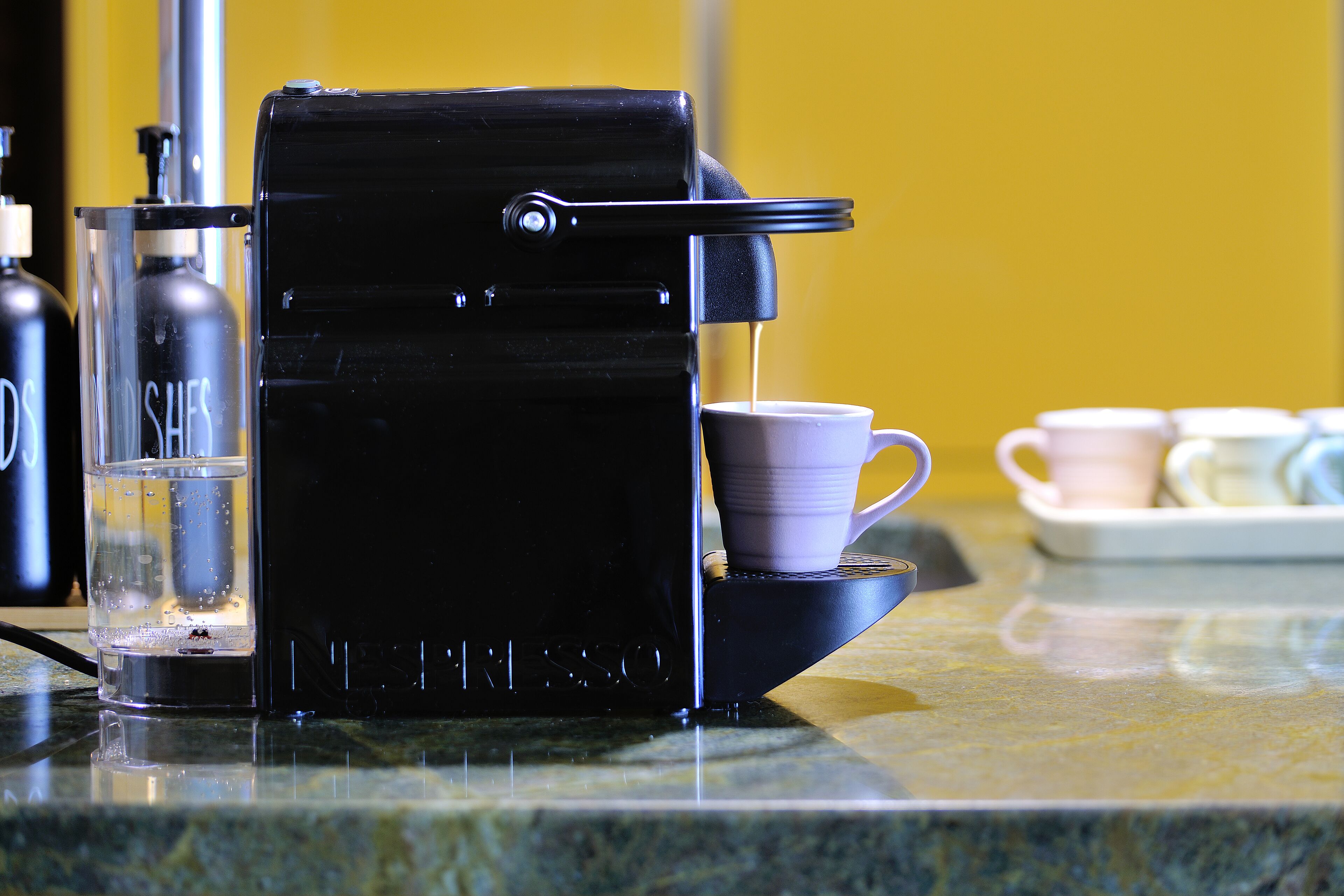Une machine à café dotée d’un réservoir d’eau et d’un porte-tasse.