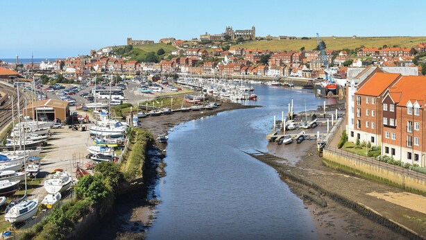 A harbor with boats, a castle in the background, and buildings along the waterfront. - 3 bedroom accommodation in Whitby (Whitby)