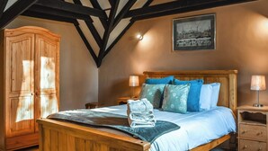 A bedroom with a wooden bed, a nightstand, a wooden wardrobe, and a framed picture on the wall. - 3 bedroom accommodation in Whitby (Whitby)