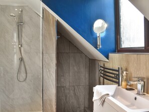 Une salle de bain avec une douche, un lavabo et un miroir.